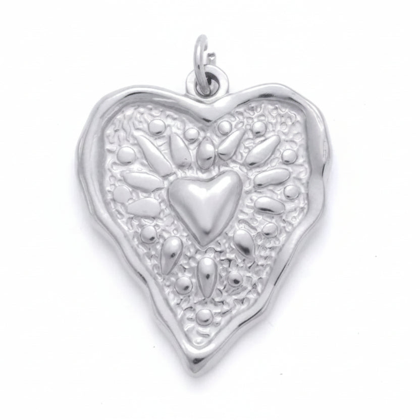 A silver heart-shaped pendant with a textured floral pattern and a central heart motif, shown with dimension labels indicating 26mm height and 21mm width on a white background.